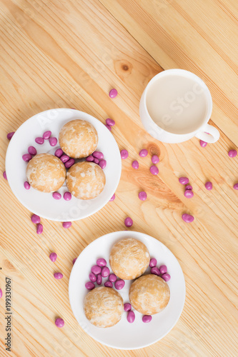 gingerbread on plates, coffee wiht milk and pink candy on a wooden background. breakfast or snack