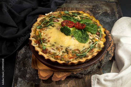 French opened pie quiche with tuna / chicken, broccoli, spinach, pepper, eggs, cheese and dried tomato. photo