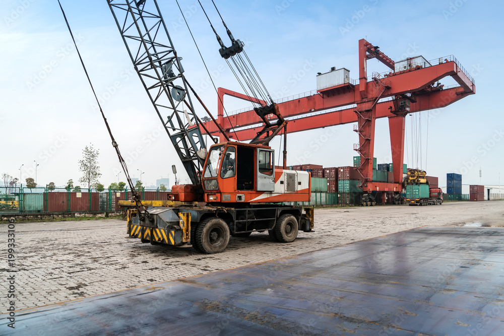The crane is hoisting containers at the wharf The crane is hoisting containers at the wharf