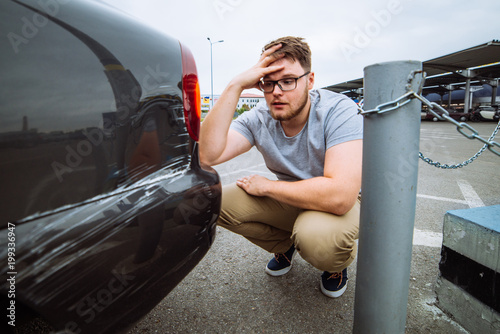 sad man sit near dint car with sad face. insurance case.