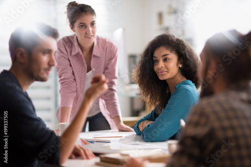 meeting at the company. A young woman leads a multi-ethnic gro