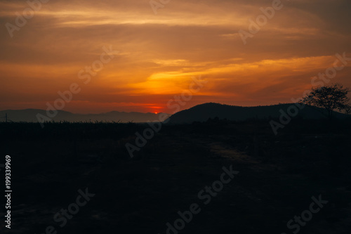 orange sunrise on the background of the silhouette of the mountains © alexkoral