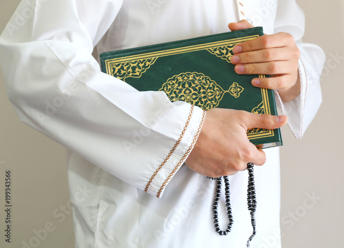 Hand of muslim man carry holy Quran . Quran - holy book of Muslims around the world. Concept of Quran