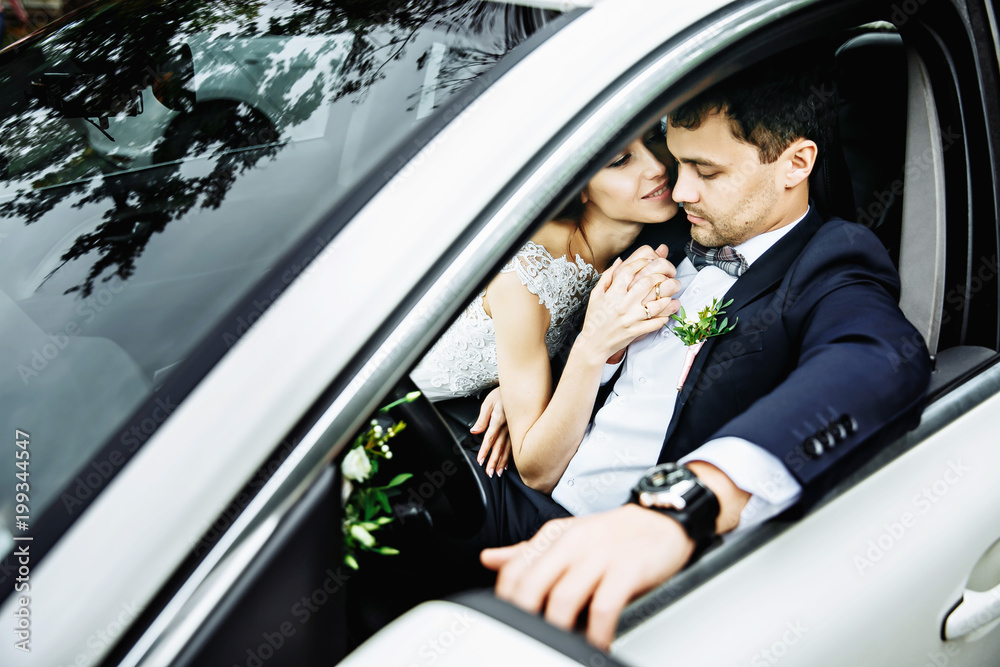 Wedding couple sitting and kissing in the car on their wedding day. Wedding couple sitting and kissing in the car on their wedding day.