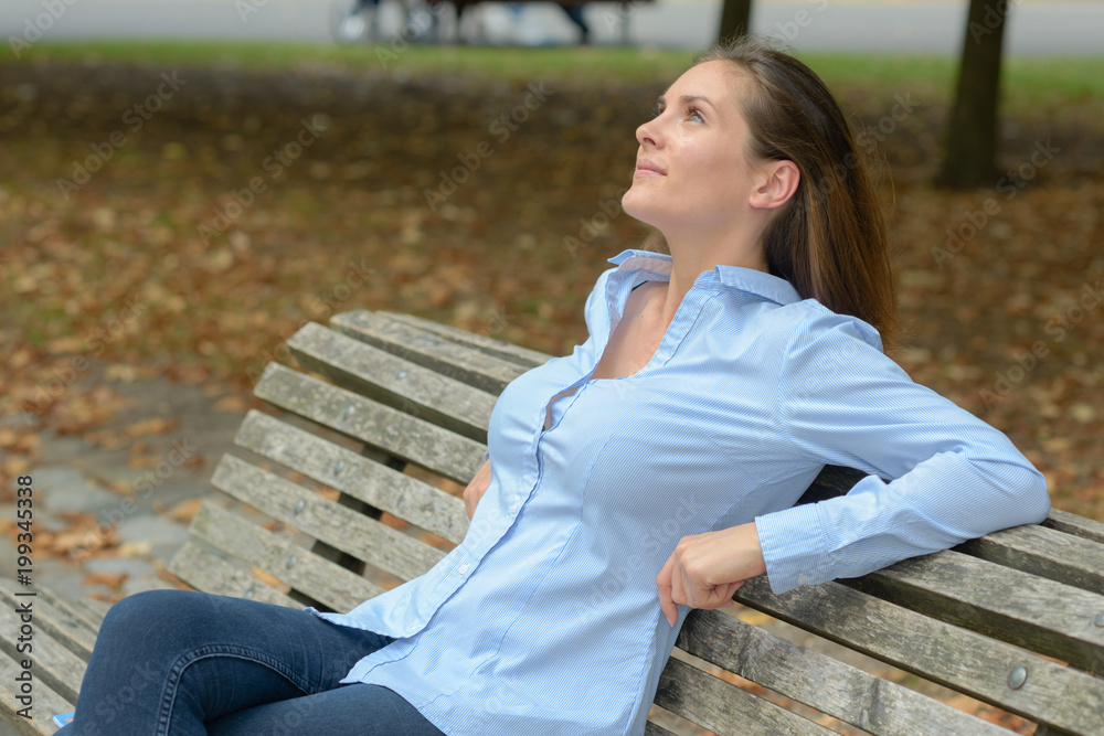 attractive young adult female on bench outdoors attractive young adult female on bench outdoors