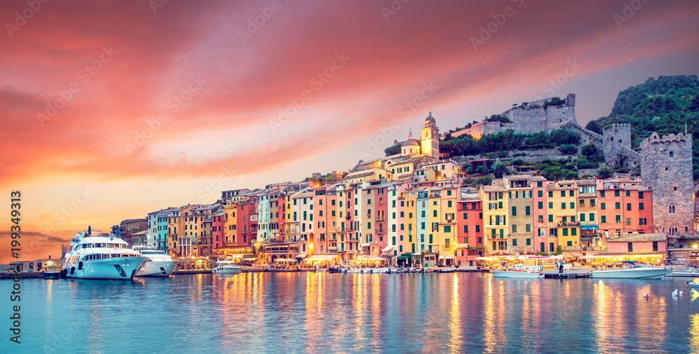 Mystic landscape of the harbor with colorful houses in the boats in Porto Venero, Italy, Liguria in the evening in the light of lanterns at sunset