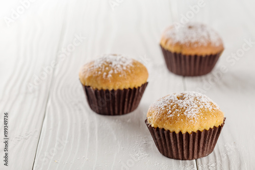 Classic muffins on a wooden old background in a brown paper.
