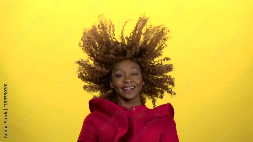 Girl jumps up and has fun. Yellow background. Slow motion Girl jumps up and has fun. Yellow background. Slow motion