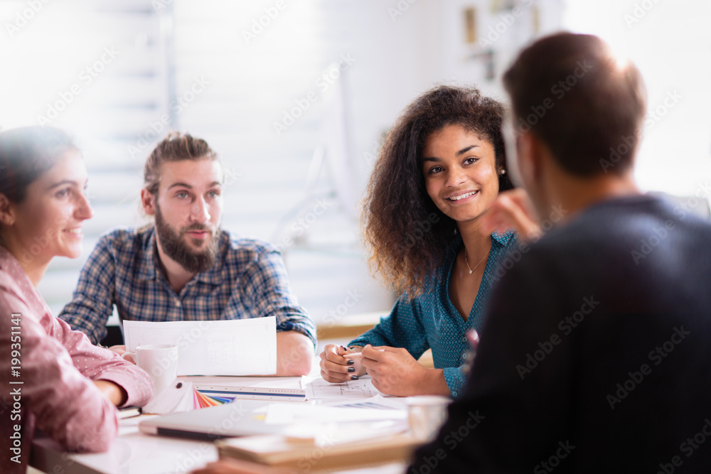 Fototapeta premium At office. A young man leads a multiethnic working group