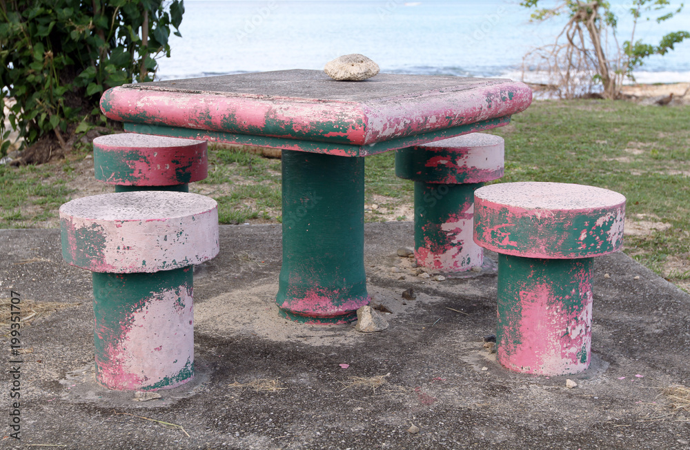 concrete pink and green painted picnic table with stools, St. Croix, U.S. Virgin Islands,Lesser Antilles, Caribbean concrete pink and green painted picnic table with stools, St. Croix, U.S. Virgin Islands,Lesser Antilles, Caribbean
