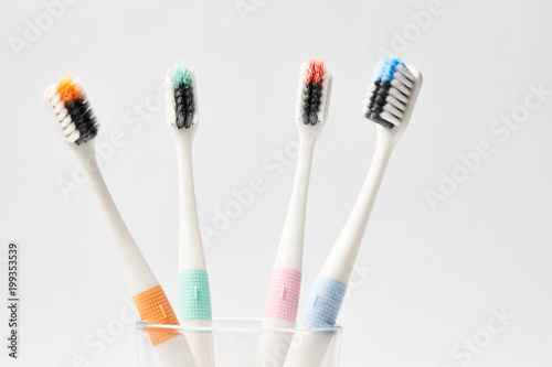 Colorful Toothbrushes in glass on white background  dental and oral care concept