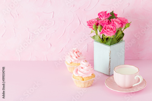 Pink pastel horisontal banner with decorated cupcakes, cup of coffe with milk and bouquet of pink roses.