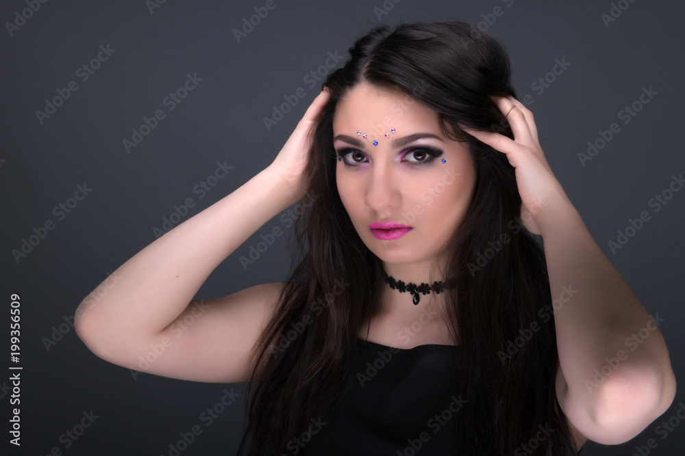 Close up face. Young arabic woman in black sexy dress, isolated on gray background Close up face. Young arabic woman in black sexy dress, isolated on gray background