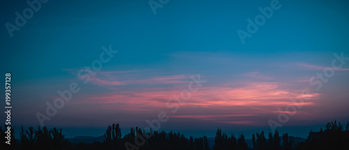 Landscape with dramatic light - beautiful golden sunset with saturated sky and clouds.