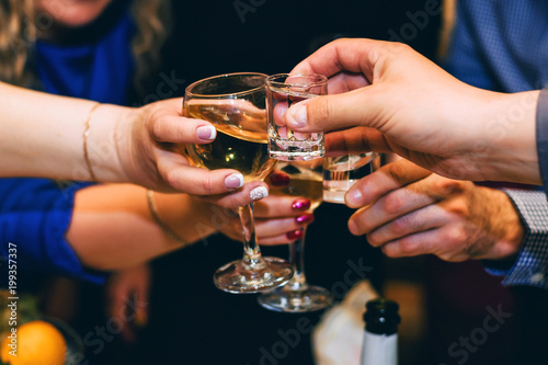 hands with glasses of wine and vodka friends celebrate the holiday