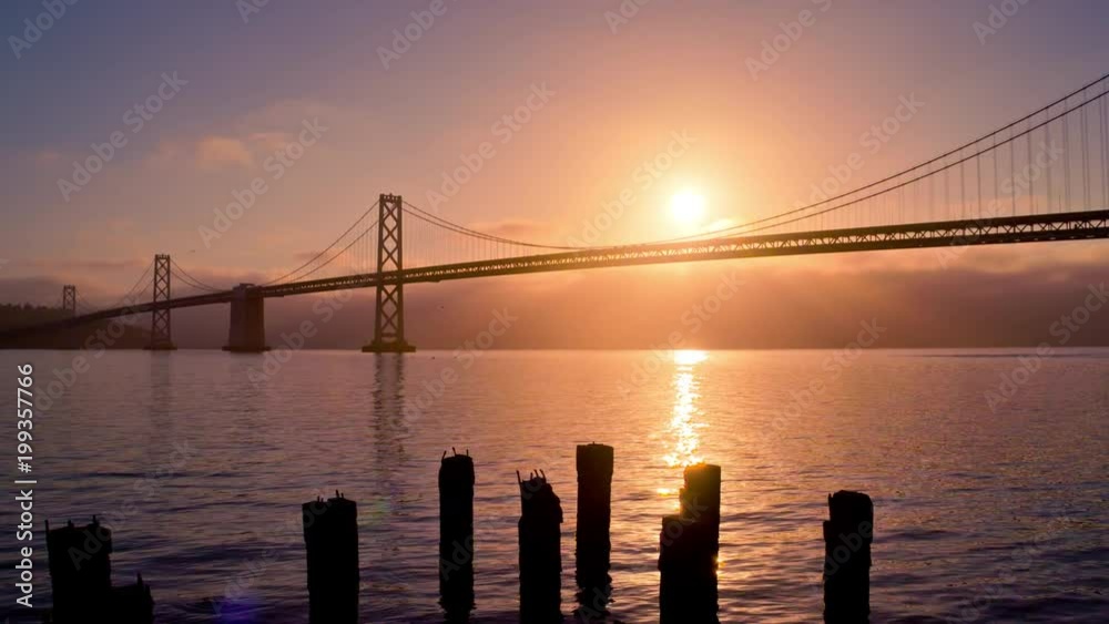 The sun rises from behind the Bay Bridge in San Francisco. The sun rises from behind the Bay Bridge in San Francisco.