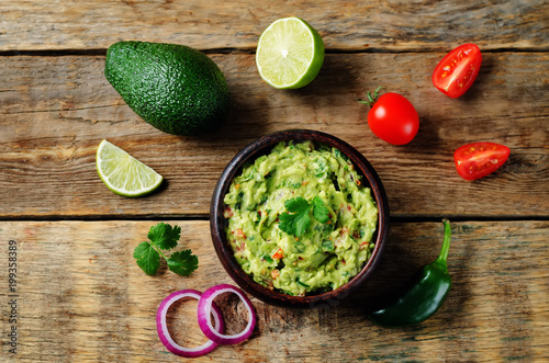 Guacamole with flying corn chips and ingredients to prepare it