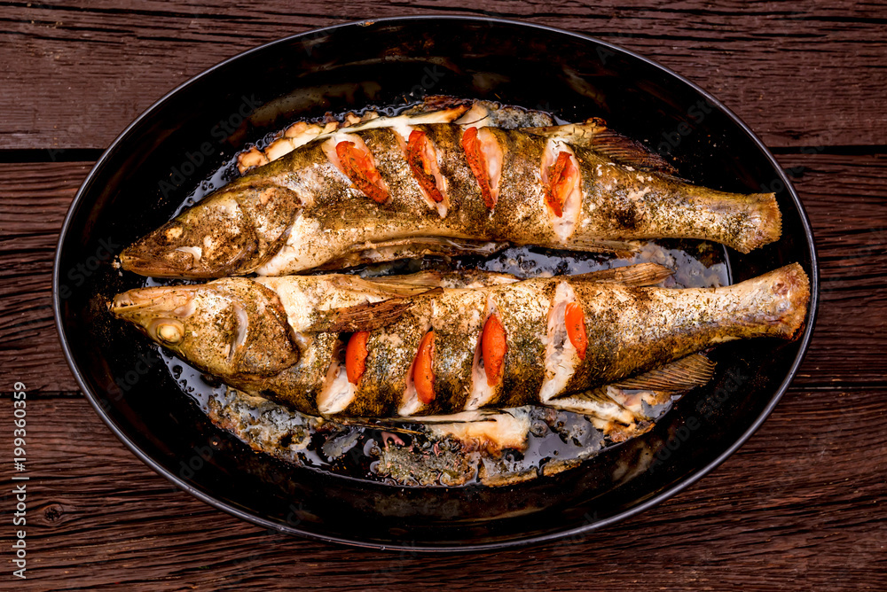 Top view zander fillet with tomatoes on frying pan Top view zander fillet with tomatoes on frying pan