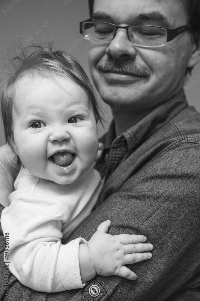 The baby is in the hands of his dad. The baby is in the hands of his dad.