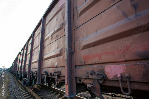 view from the side to the long train of metal freight cars