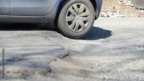 The car goes  a pothole. Wheels close up.