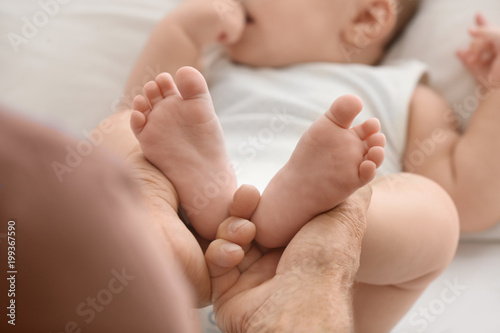 Senior man playing with his little grandchild at home, closeup