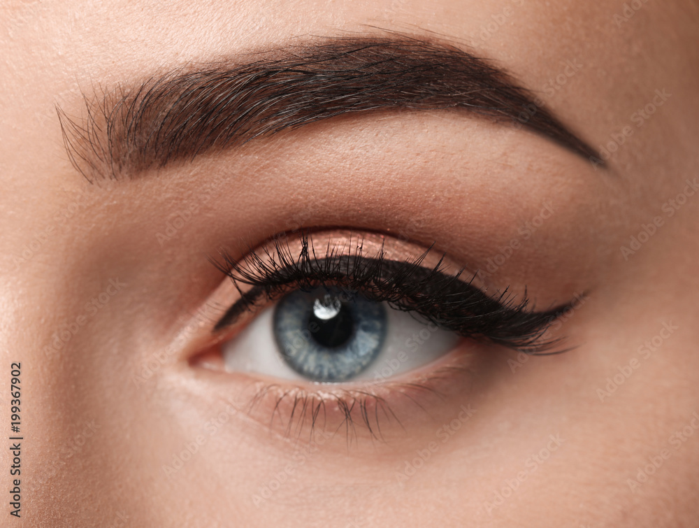 Eye of young woman with beautiful eyebrow after correction, closeup Eye of young woman with beautiful eyebrow after correction, closeup