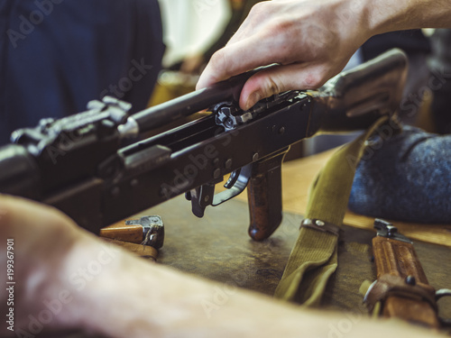 man disassemble rifle close up on the table photo