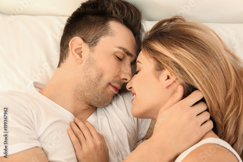 Beautiful young couple sleeping in bed at home