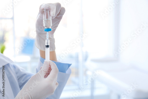Female doctor with vial and syringe in hospital. Vaccination day