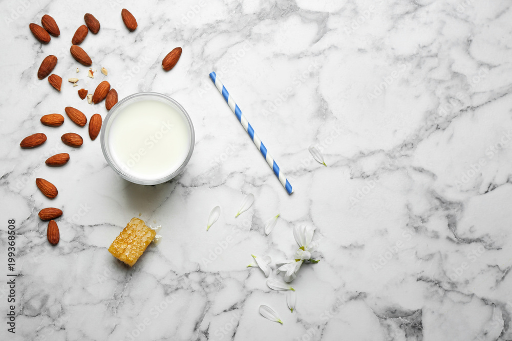 Glass with milk, nuts and honeycomb on light background, flat lay Glass with milk, nuts and honeycomb on light background, flat lay