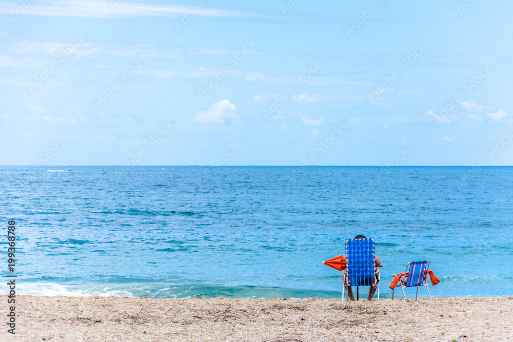 chair, umbrella and person on the beach.