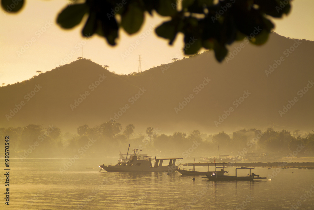 Obraz premium Balinese Fishing Boats Anchored in the Village of Pemuteran. Balinese fishing boats, called jukung, in the bay of northwest Bali, Indonesia during a beautiful sunrise. 