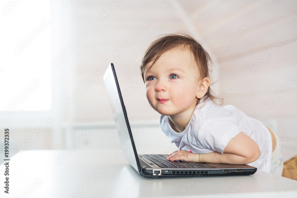 Portrait of smiling little baby girl with a laptop at home Portrait of smiling little baby girl with a laptop at home