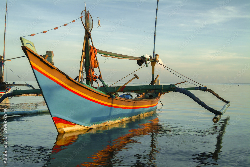 Balinese Fishing Boats Anchored in the Village of Pemuteran. Balinese fishing boats, called jukung, in the bay of northwest Bali, Indonesia during a beautiful sunrise. 