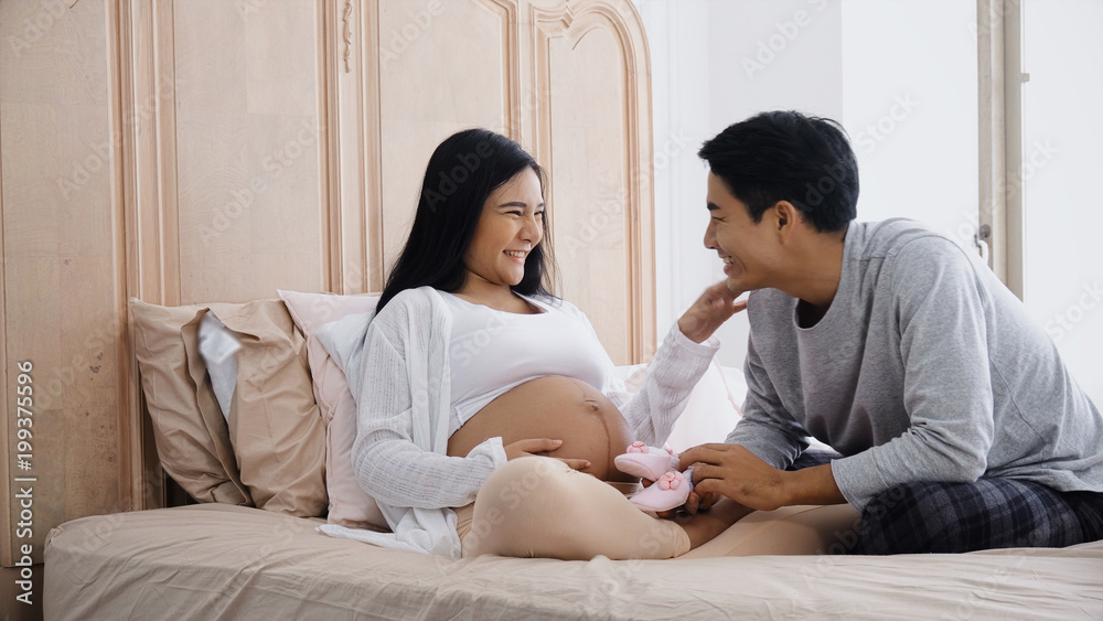 The parent talking and playing little shoes on belly pregnant The parent talking and playing little shoes on belly pregnant