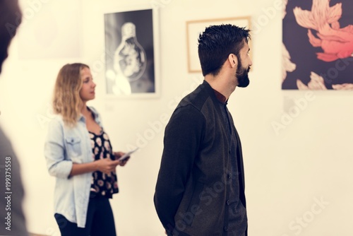 People looking at frames in exhibition