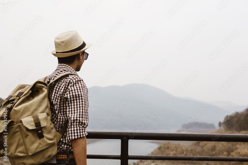Obraz premium Young man tourist see view of mountain on bridge.