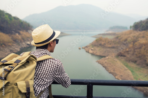 Young man tourist see view of mountain on bridge.