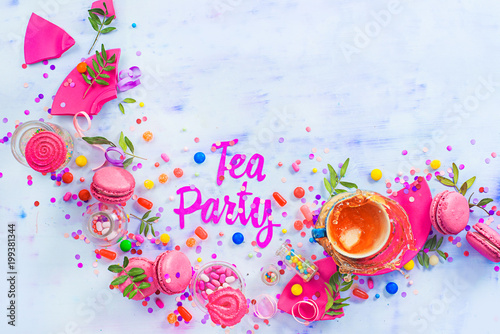 Tea party concept with paper text, candies, sweets, confetti, macarons and dynamic tea splash. Colorful Birthday celebration flat lay with copy space.