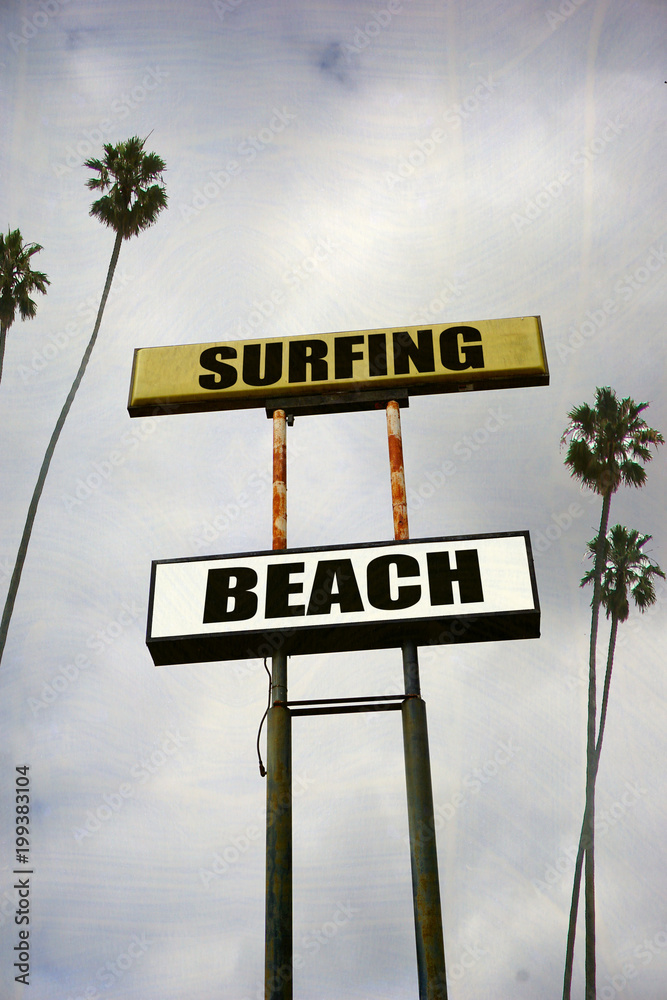 Fototapeta premium aged and worn surfing beach sign with palm trees