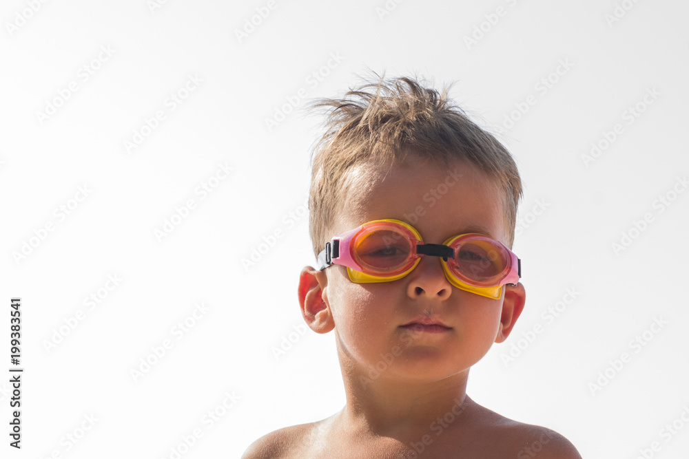 Little boy in swimming goggles on the beach