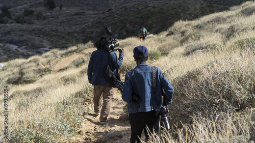 camera crew walking down hillside