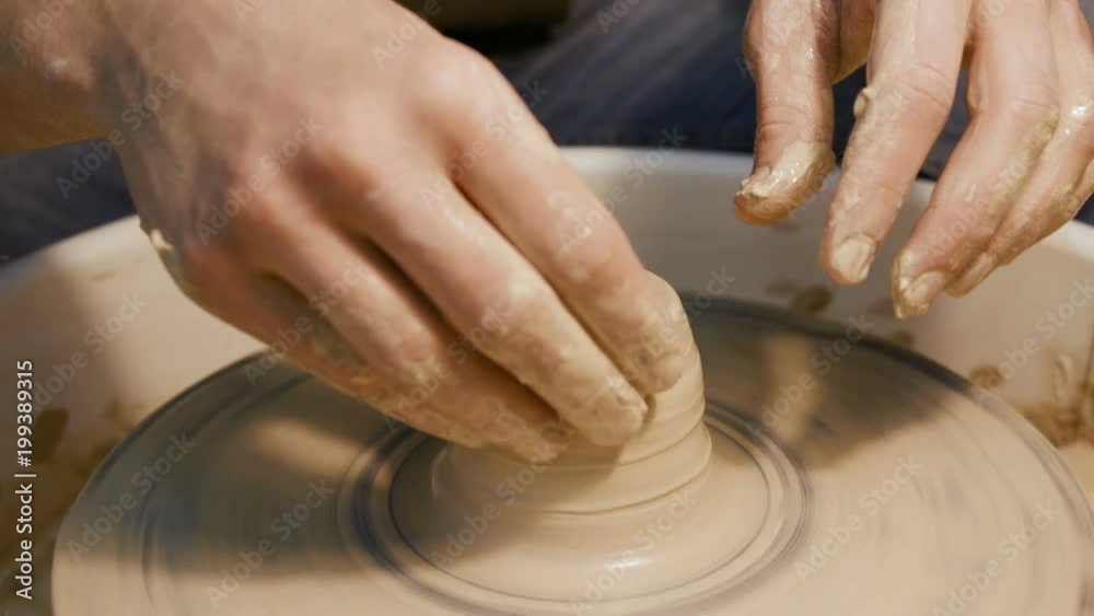 Male craftsperson sculpt process on the round potterswheel closeup isolated. Artisan dexterity creating product - cup or vase from wet brown mud. Lifestyle, leisure, creativity concept of background Male craftsperson sculpt process on the round potterswheel closeup isolated. Artisan dexterity creating product - cup or vase from wet brown mud. Lifestyle, leisure, creativity concept of background