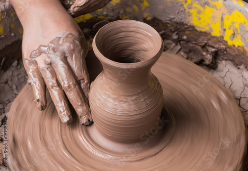 hands of a potter, creating an earthen jar on the circle