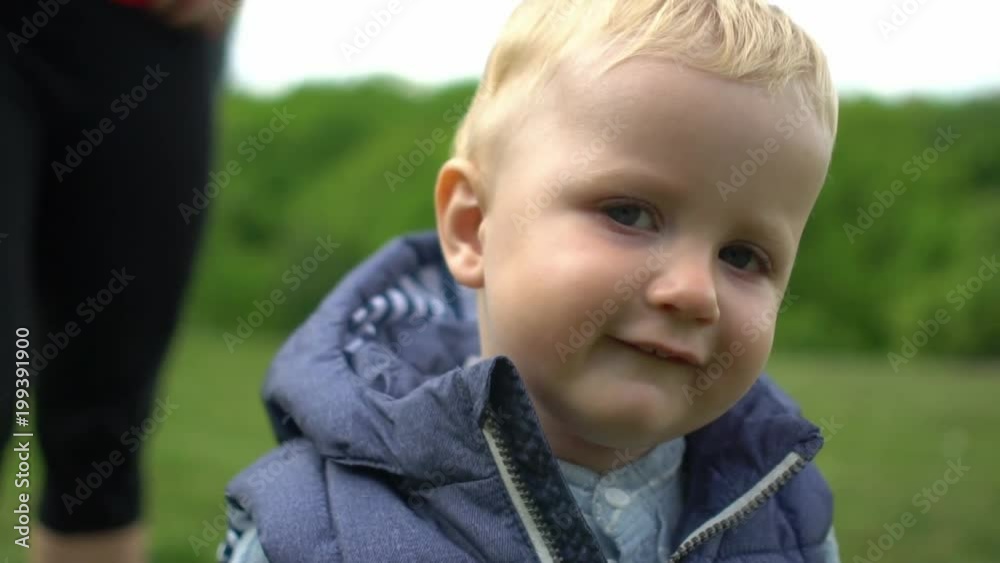 One year old cute boy making his first steps with his mother in park Slow motion One year old cute boy making his first steps with his mother in park Slow motion