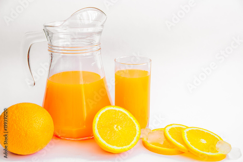 Composition of freshly squeezed orange juice, whole orange and slices on a white background