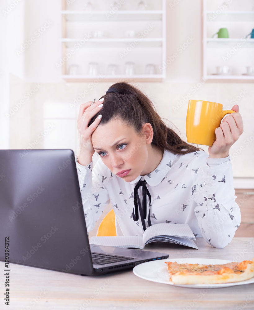 Tired woman working on laptop at home