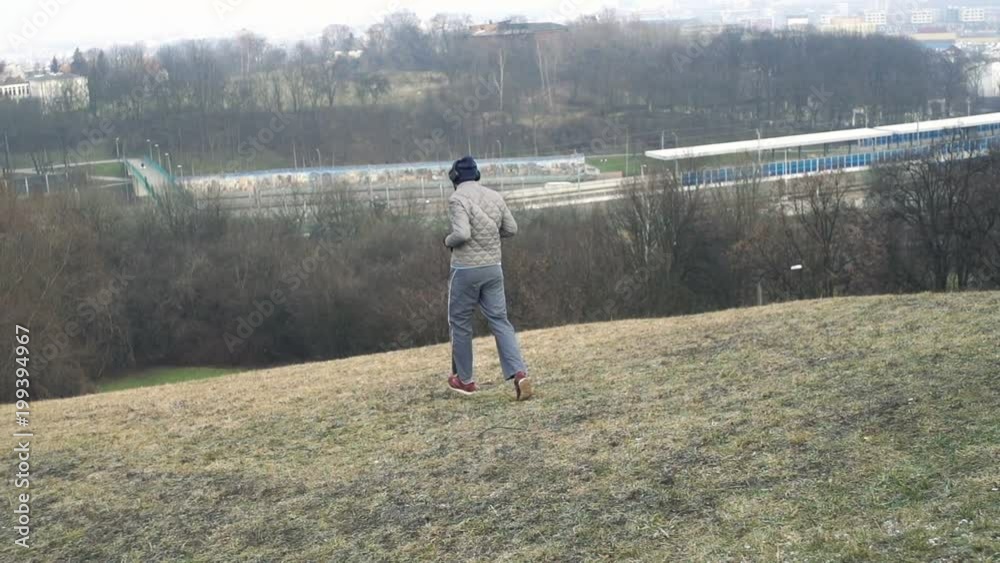 Male jogger running down hill in city park, super slow motion 120fps
