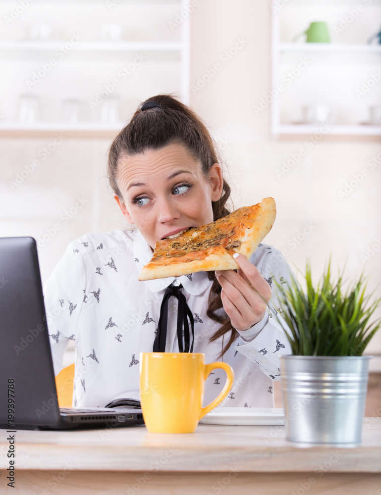 Woman eating fast food and working on laptop Woman eating fast food and working on laptop